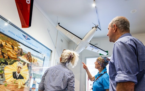 Visitors observing Royal Flying Doctor Service exhibit in Alice Springs museum.