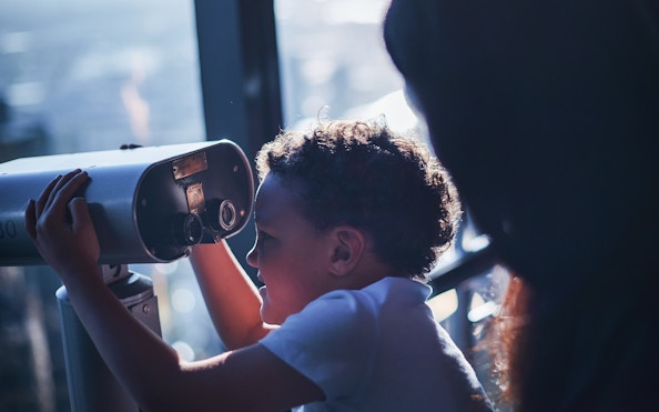 Child looking through binoculars at Melbourne Skydeck.