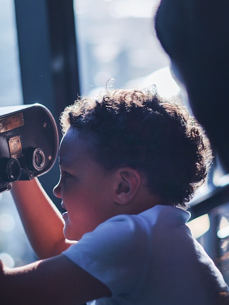 Child looking through binoculars at Melbourne Skydeck.