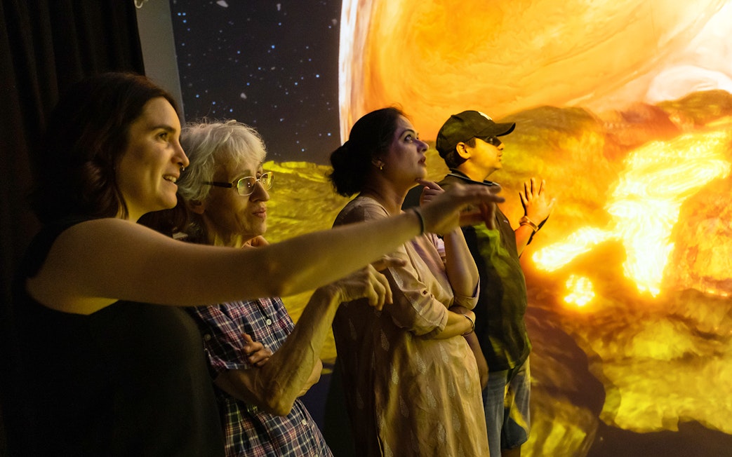 Visitors observing a planetary display at Espai Crater.