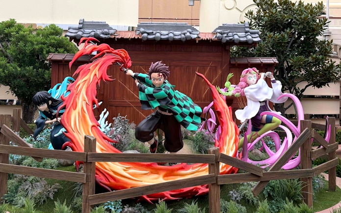 Characters from an anime series in action poses at Universal Studios Japan.