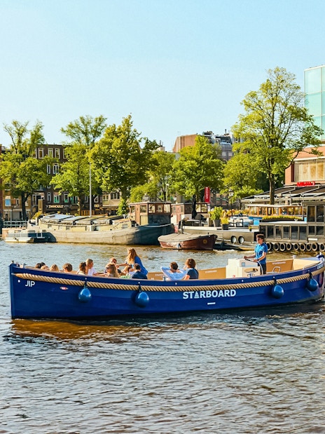 Canal boat with tourists on Amsterdam's Red Light District cruise.