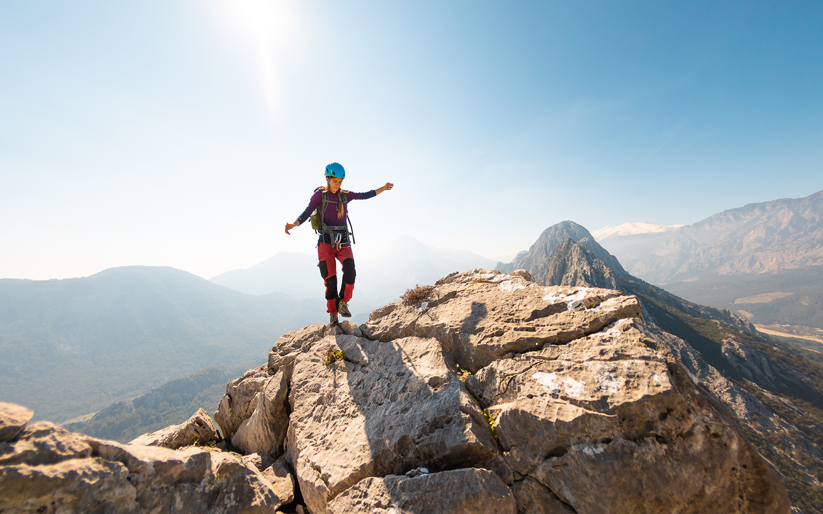 Climber balancing on rocky mountain ridge with scenic view, Blue Planet Aquarium tour.