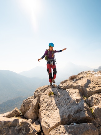 Climber balancing on rocky mountain ridge with scenic view, Blue Planet Aquarium tour.