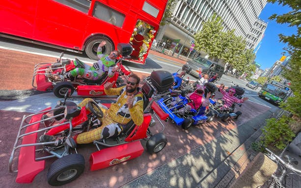 Go-kart riders in costumes on a Tokyo street near Asakusa during a photoshoot experience.