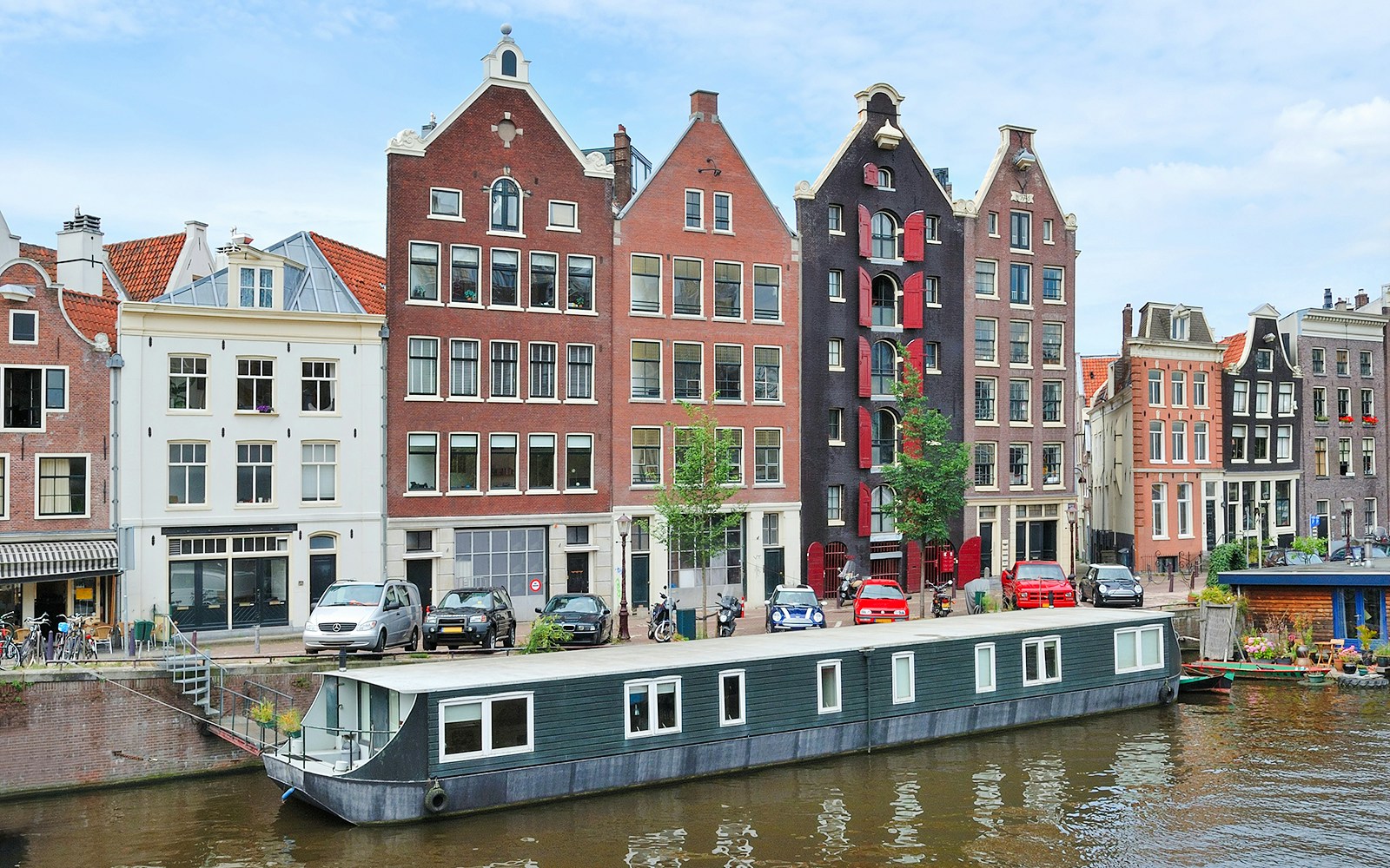 Canal houses and houseboat on Kromme Waal, Amsterdam.