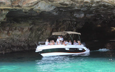 Boat navigating a cave on a tour in Polignano a Mare, Italy.