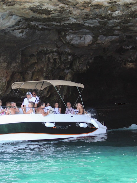 Boat navigating a cave on a tour in Polignano a Mare, Italy.