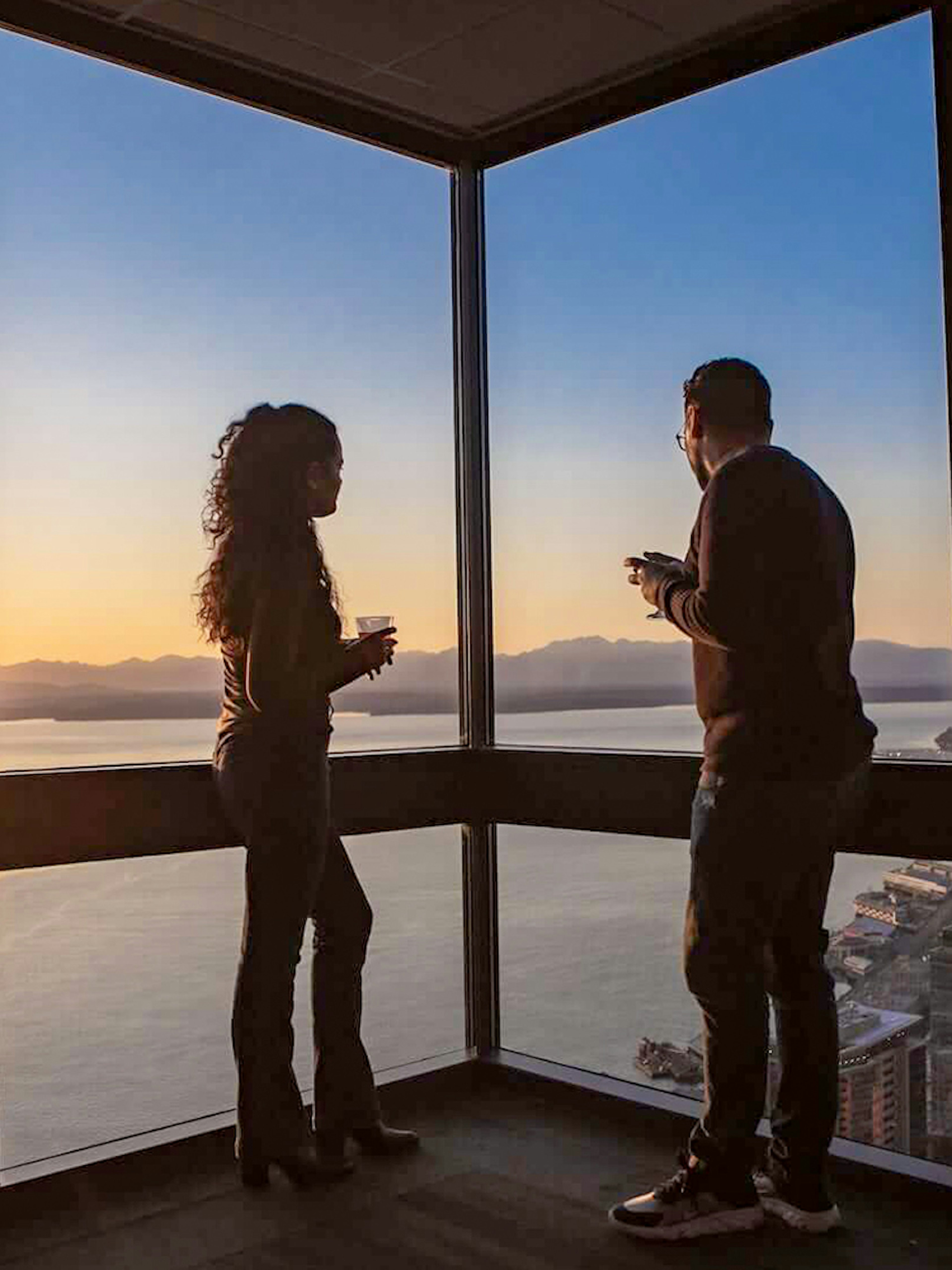 Two people enjoying sunset views from Sky View Observatory in Seattle.