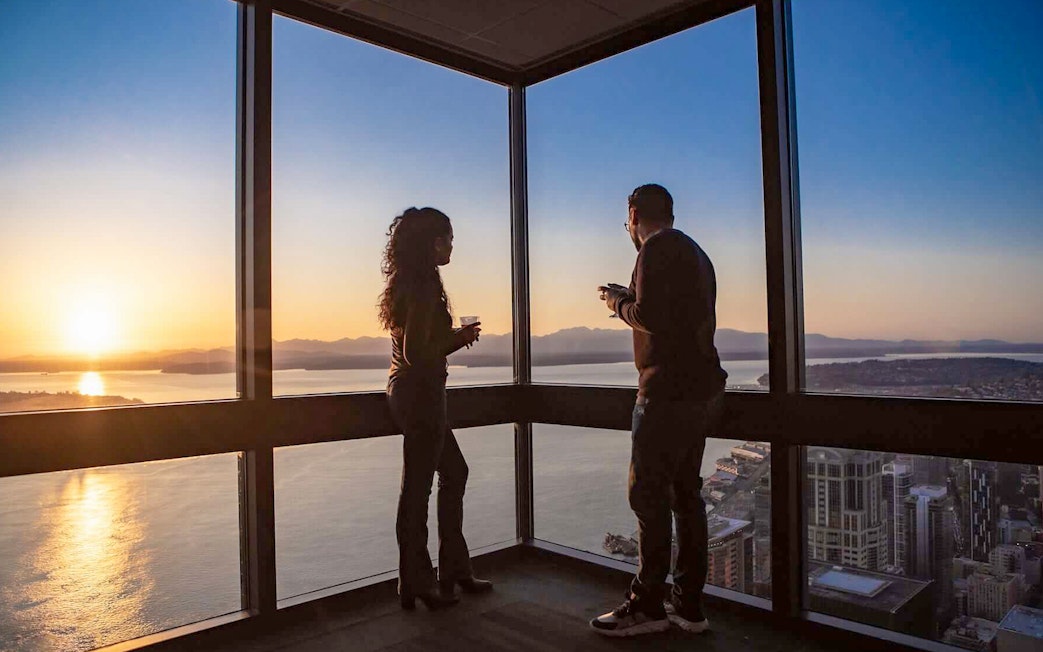 Two people enjoying sunset views from Sky View Observatory in Seattle.