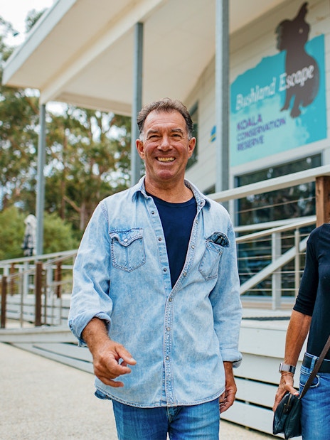 Visitors smiling outside Koala Conservation Reserve entrance, Phillip Island Nature Parks.