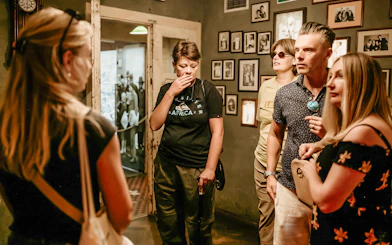 Visitors on a guided tour inside Oskar Schindler's Factory, viewing historical exhibits.