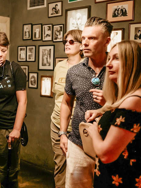 Visitors on a guided tour inside Oskar Schindler's Factory, viewing historical exhibits.