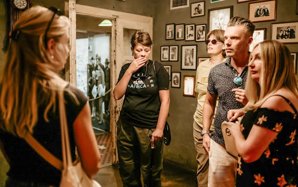 Visitors on a guided tour inside Oskar Schindler's Factory, viewing historical exhibits.