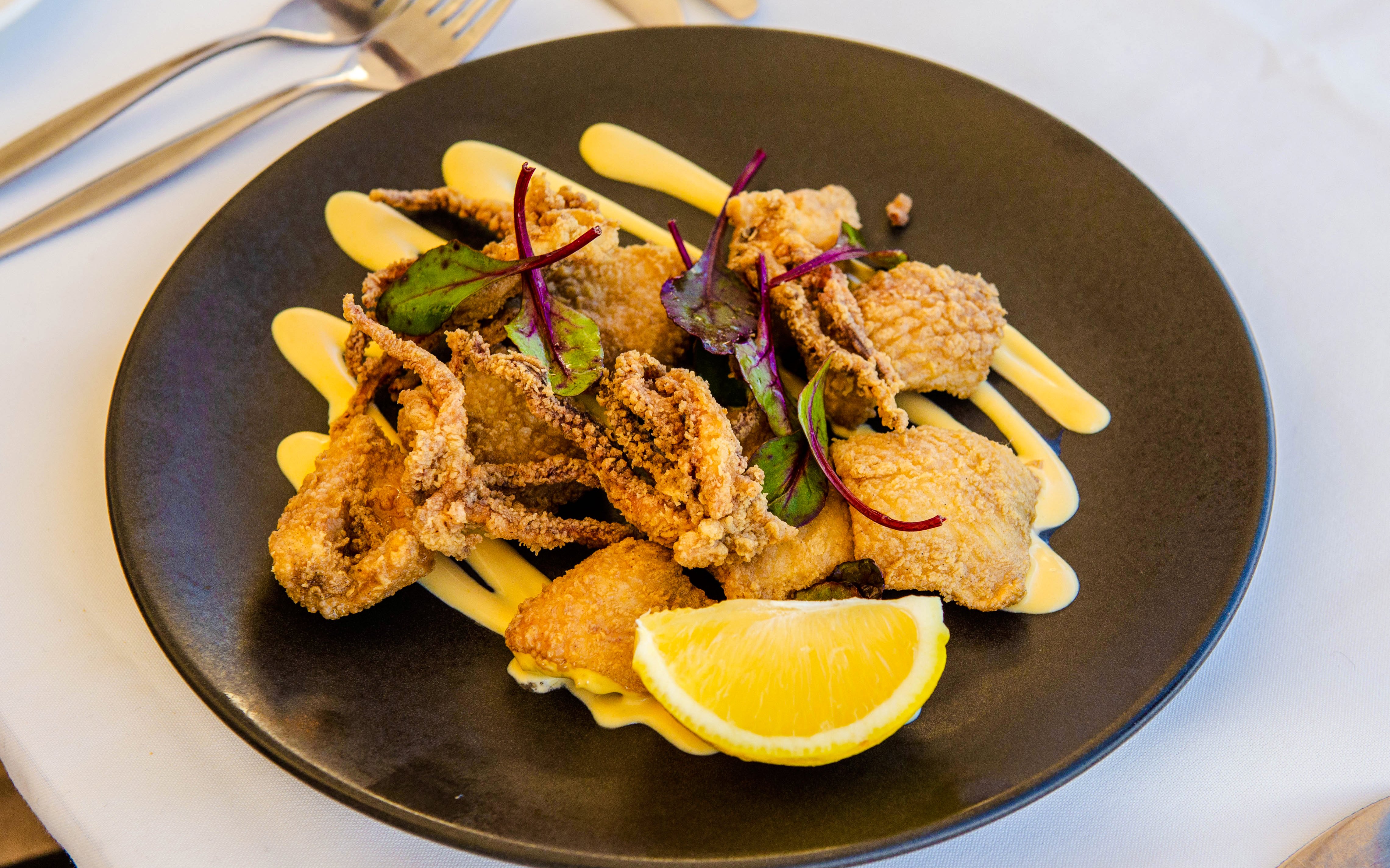 Fried seafood dish with lemon wedge on Sydney Harbour luxury lunch cruise.