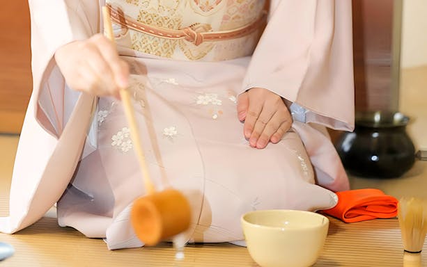 Japanese tea ceremony with traditional sweets and kimono attire.