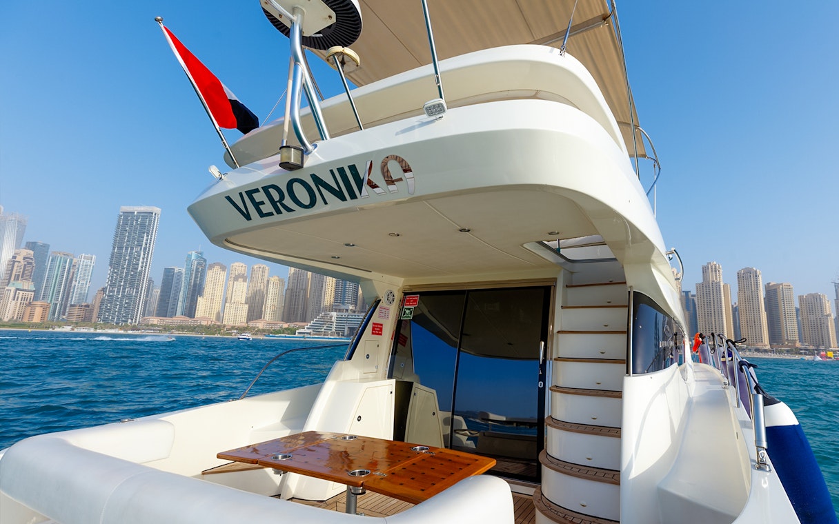Private yacht deck with Dubai Marina skyline in the background.