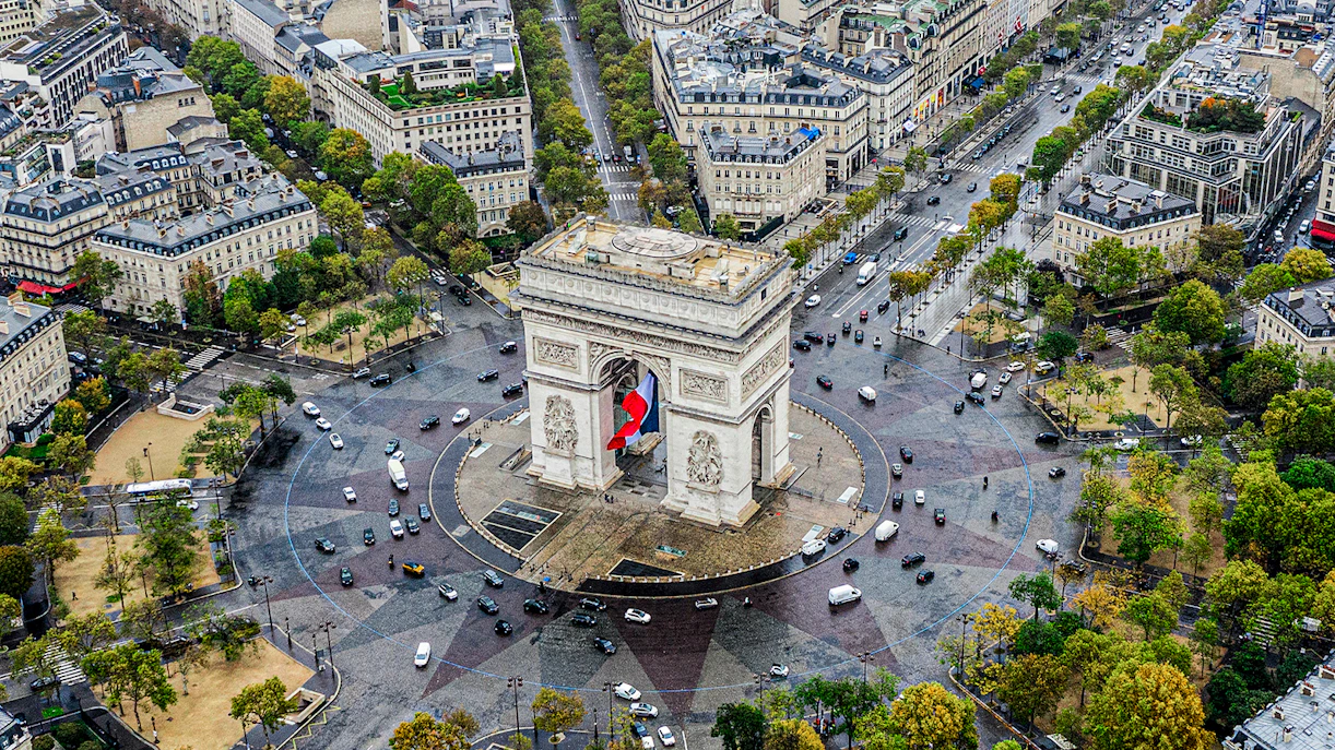 Aerial view of Arc de Triomphe in Paris with surrounding streets and buildings.