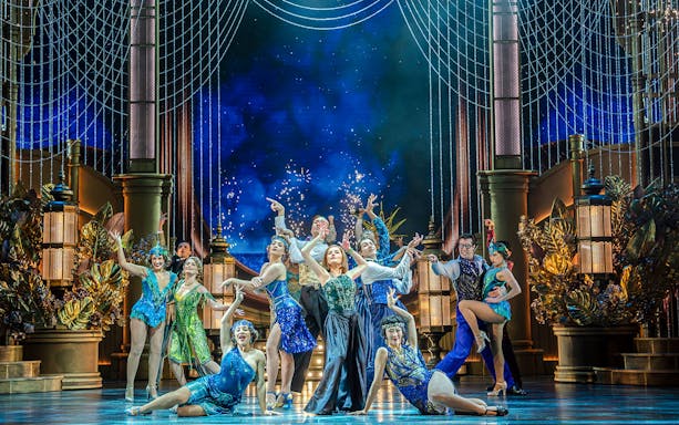 Performers in vibrant costumes on stage during The Great Gatsby Musical.