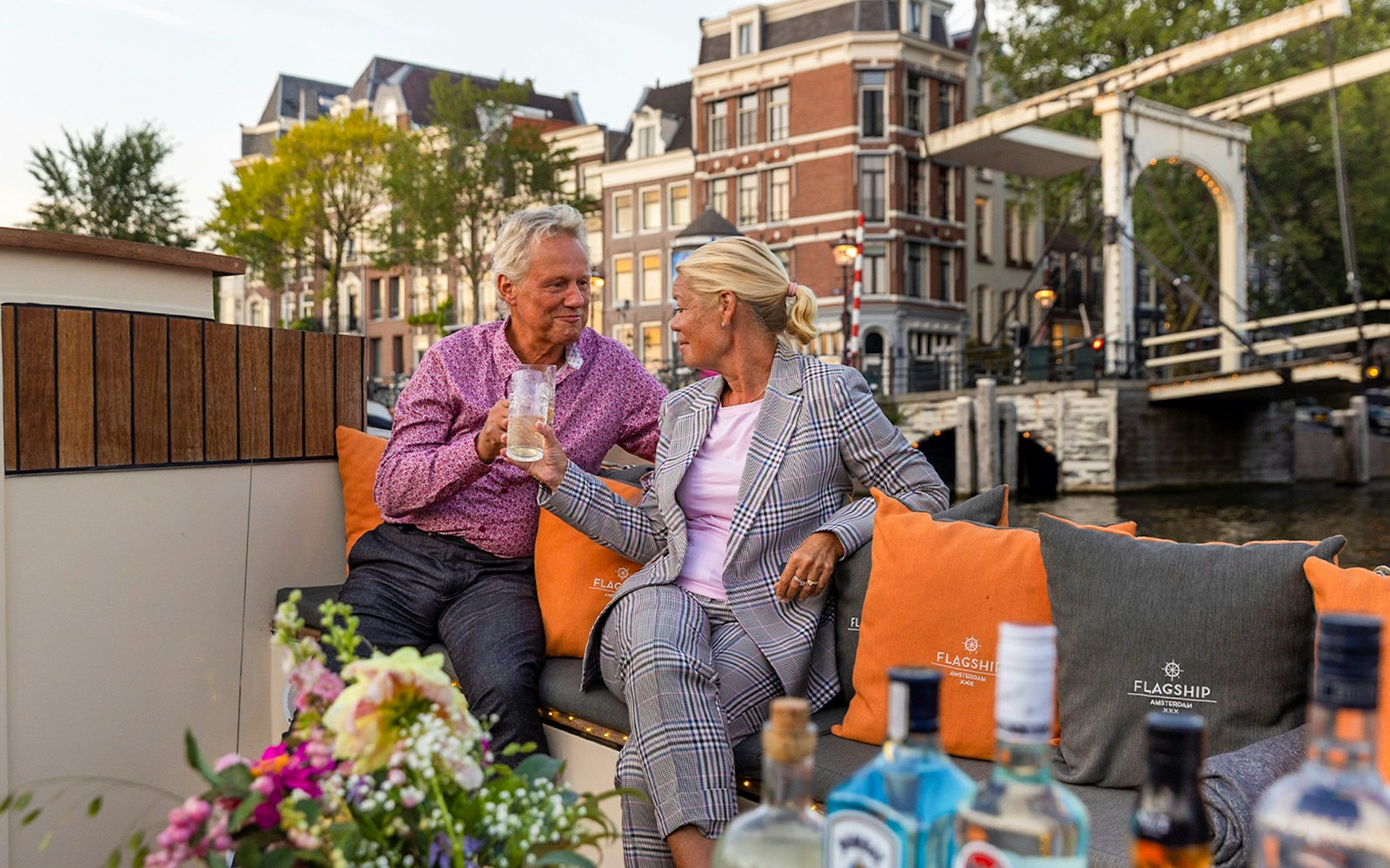 Guests enjoying cheese and wine on a classic boat cruise in Amsterdam canals.