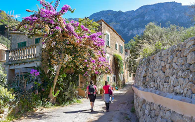 Valldemossa street with stone houses and blooming bougainvillea, part of Soller tour.