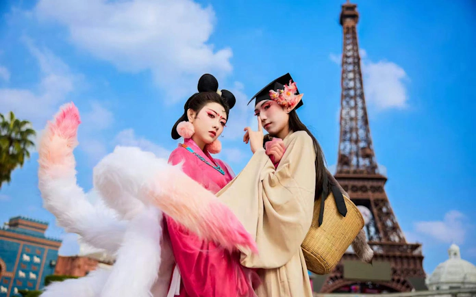 People in traditional Hanfu attire at Window of the World, Shenzhen, with Eiffel Tower replica.