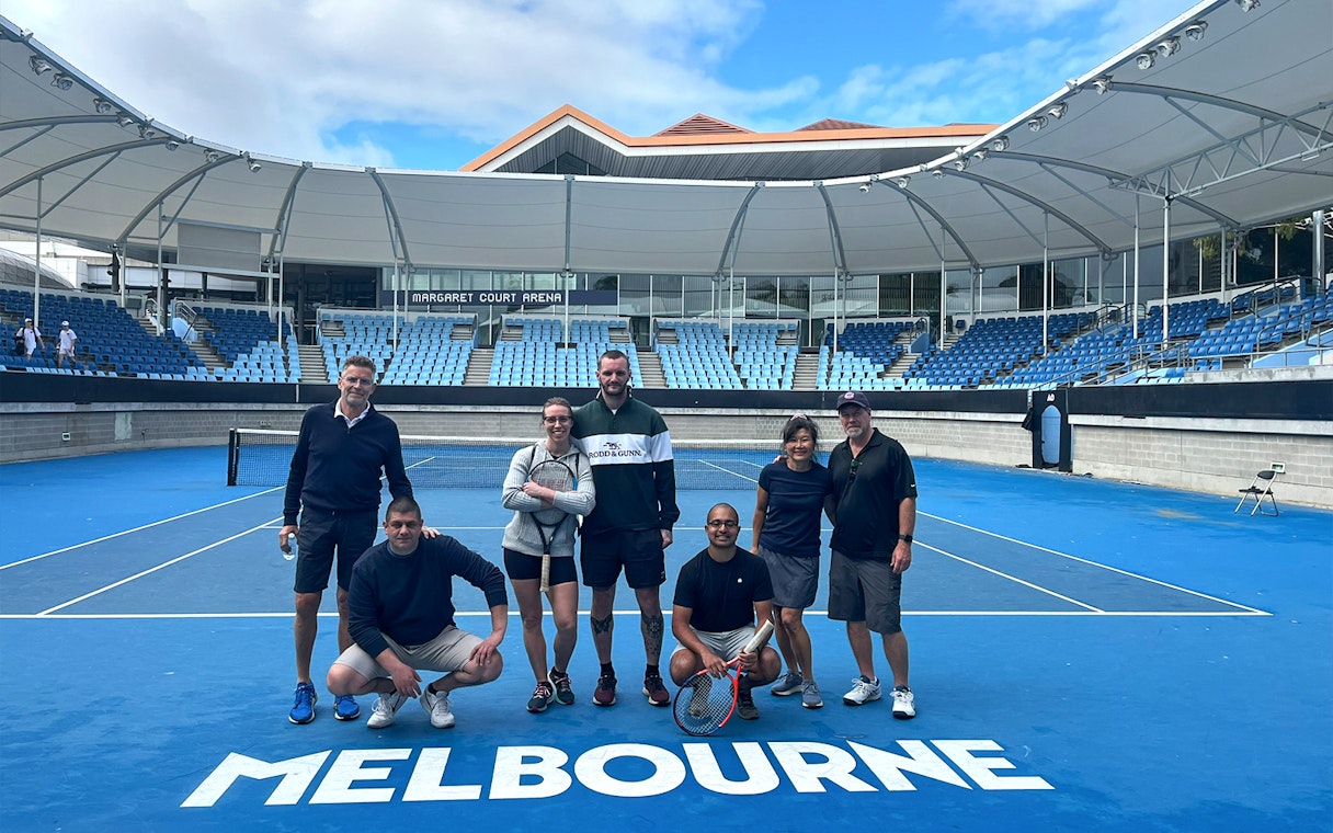Group of people on a tennis court at Melbourne Park's Margaret Court Arena.