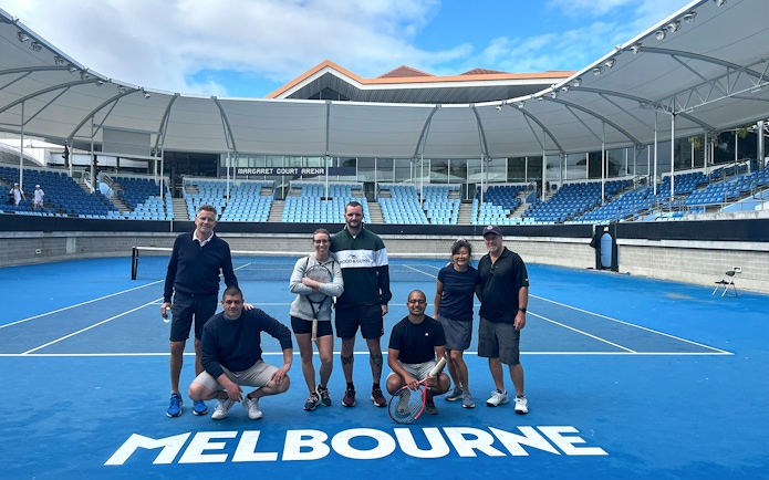 Group of people on a tennis court at Melbourne Park's Margaret Court Arena.