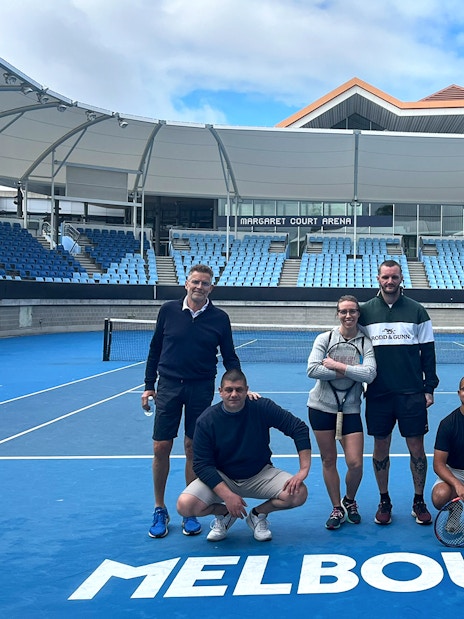 Group of people on a tennis court at Melbourne Park's Margaret Court Arena.