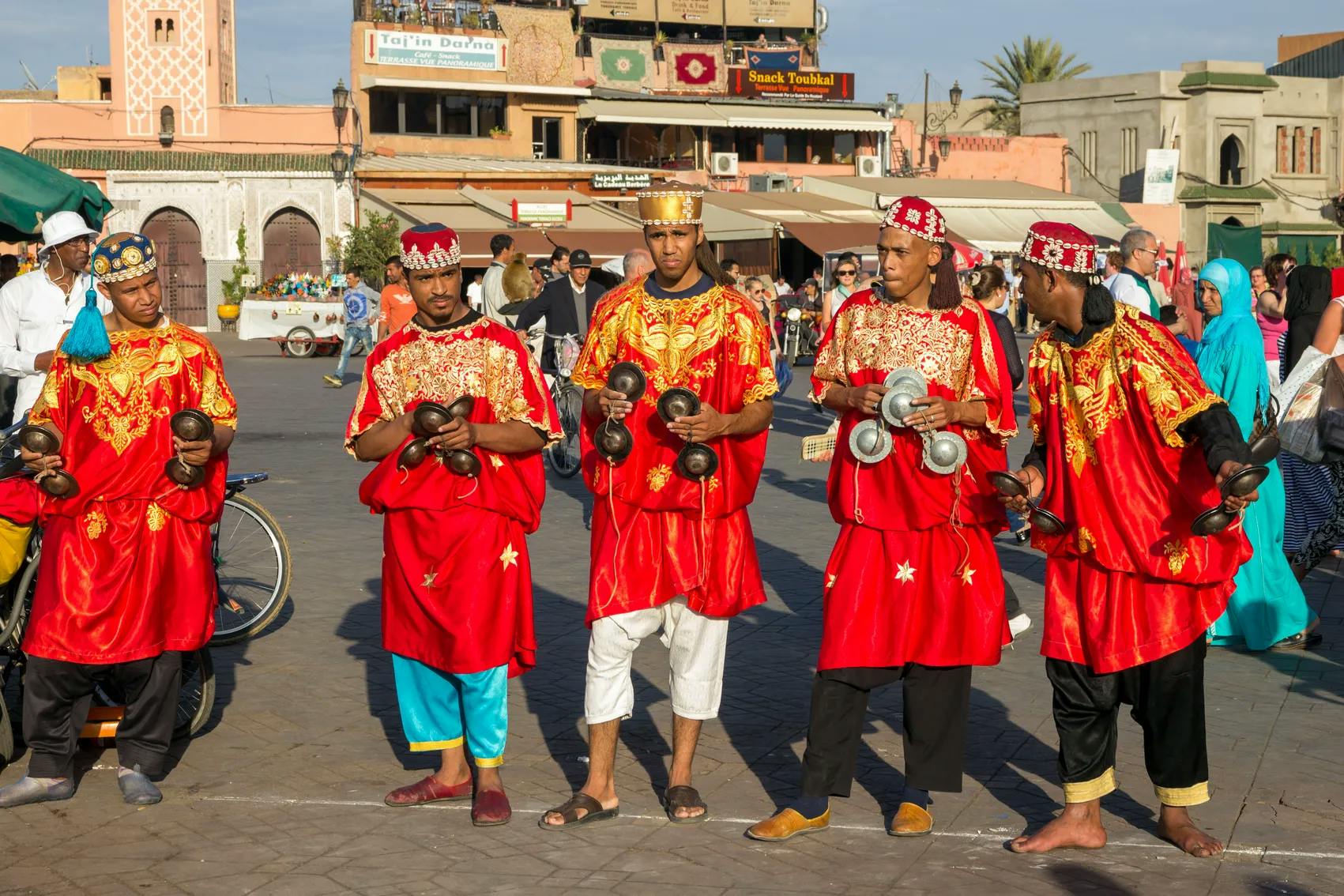Gnawa musicians in red robes performing in Jemaa el-Fnaa square, Marrakech, Morocco.