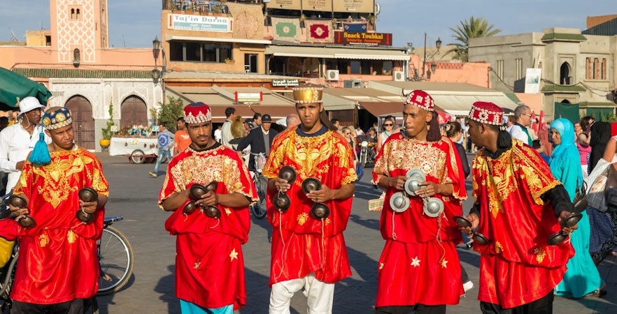 Gnawa musicians in red robes performing in Jemaa el-Fnaa square, Marrakech, Morocco.