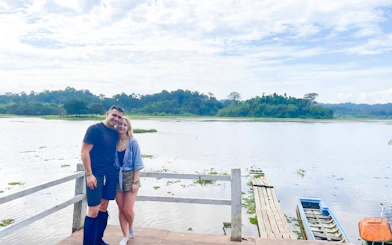 Couple standing on a dock by a river in Nam Cat Tien National Park, Vietnam.