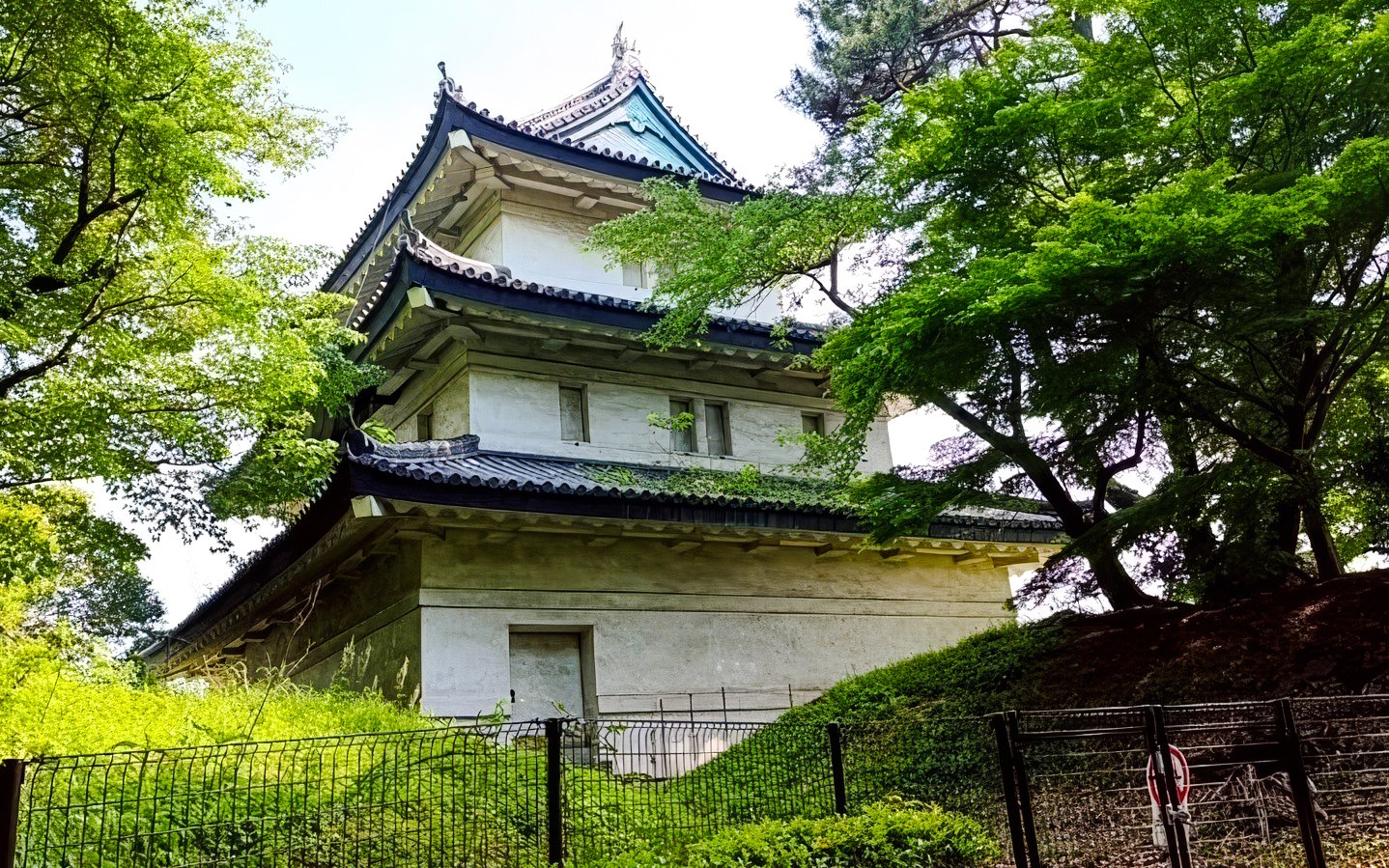 Imperial Palace guard tower surrounded by lush greenery in Tokyo.