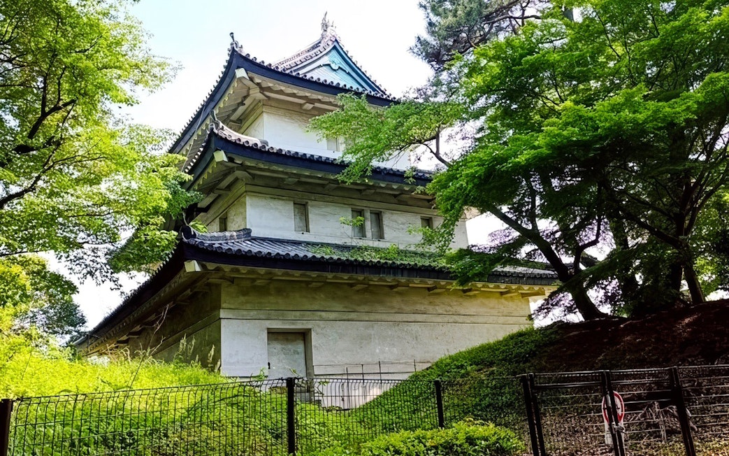 Imperial Palace guard tower surrounded by lush greenery in Tokyo.