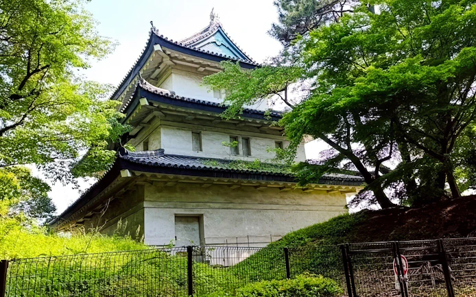 Imperial Palace guard tower surrounded by lush greenery in Tokyo.