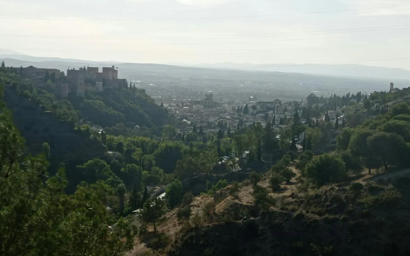 Granada cityscape with Alhambra view from Sacromonte hillside, part of self-guided exploration game.