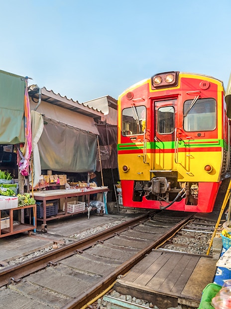 Train passing through Umbrella Fresh Market on the railroad track, Mae Klong Train Station, Bangkok.