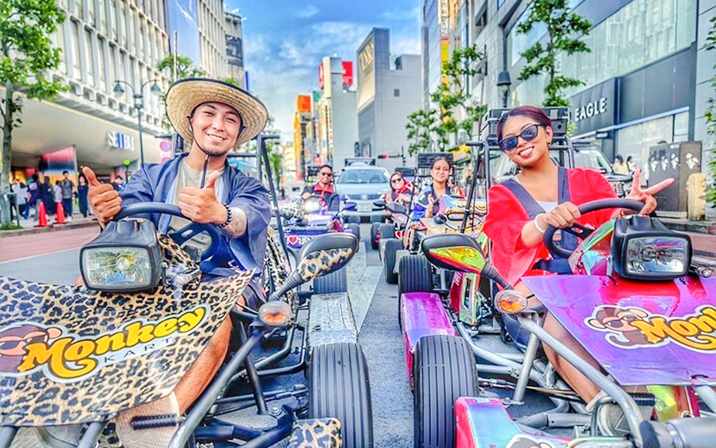 Diverse group enjoying a go-kart tour on vibrant Tokyo streets.