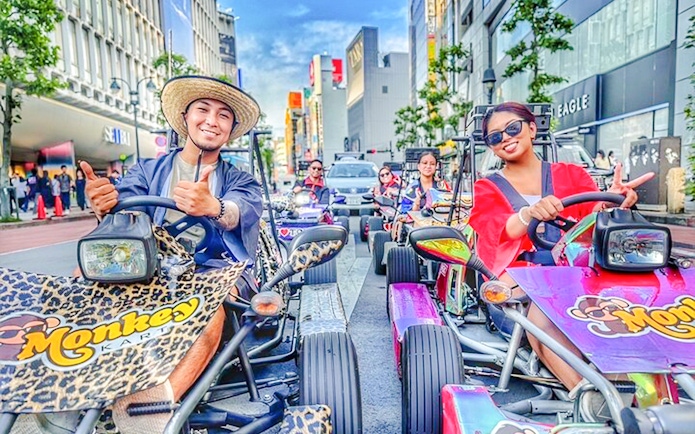 Diverse group enjoying a go-kart tour on vibrant Tokyo streets.