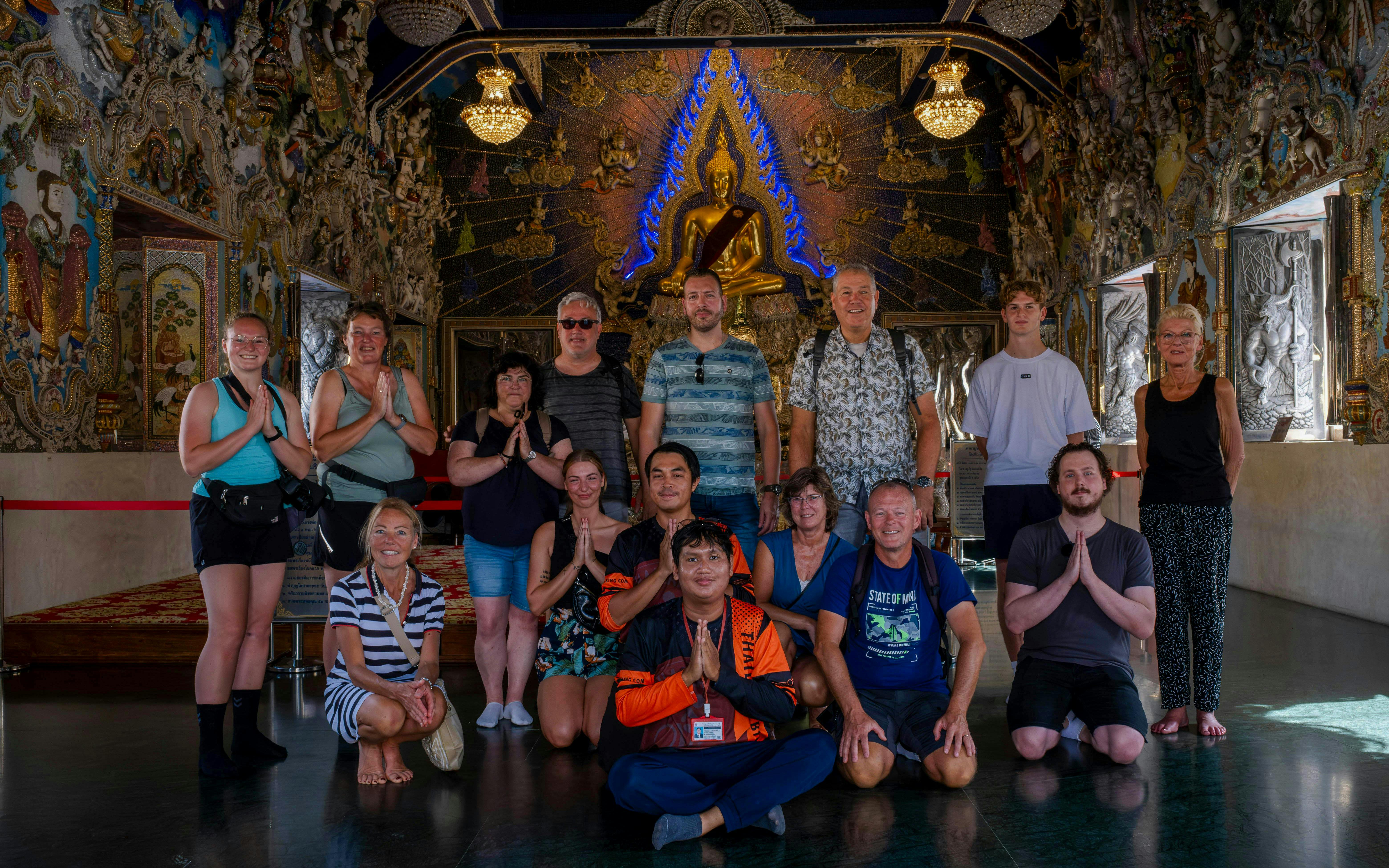 Group of tourists posing inside a decorated temple during the Bangkok Beyond Bicycle Ride.