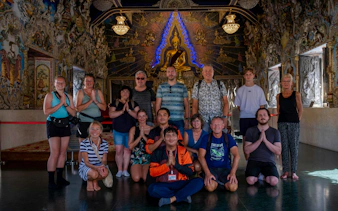 Group of tourists posing inside a decorated temple during the Bangkok Beyond Bicycle Ride.