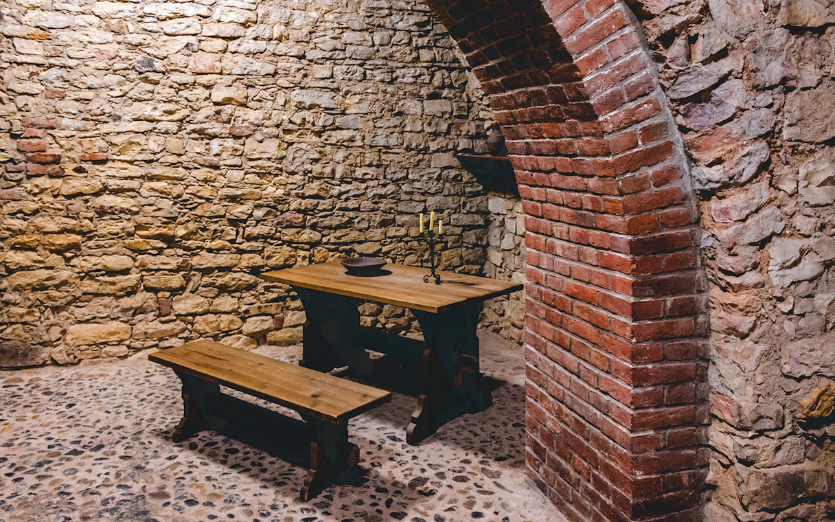 Prague medieval underground with stone walls and wooden table.
