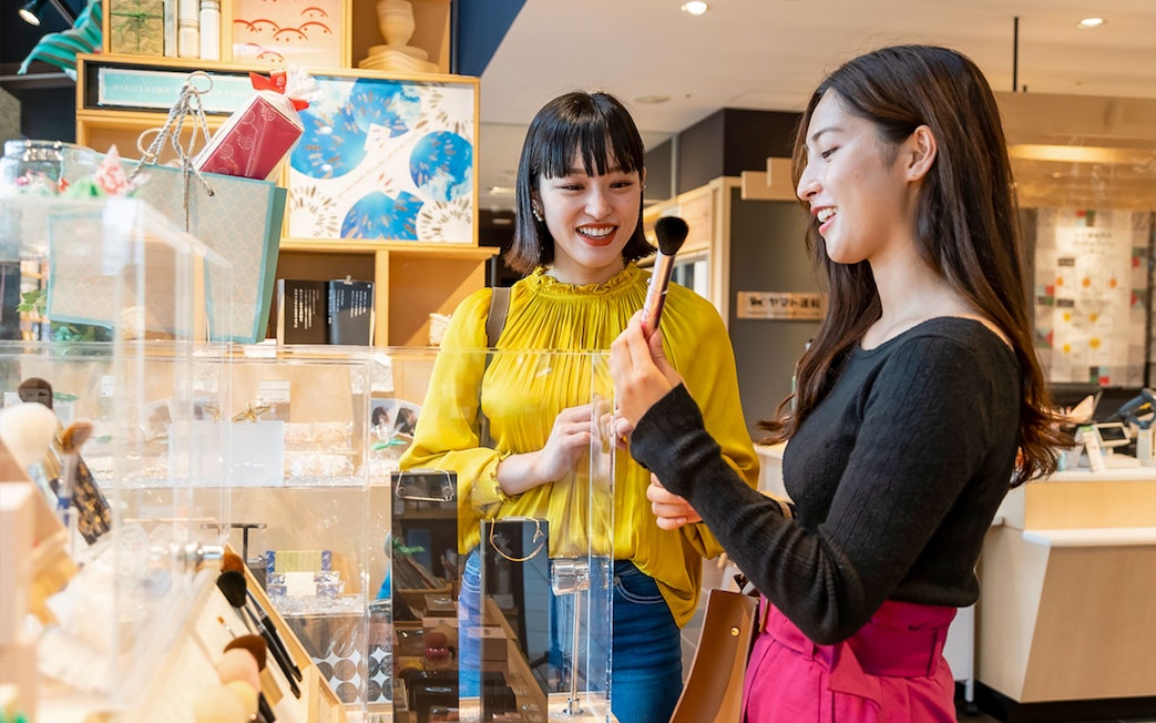 Visitors exploring gift shop at Hiroshima Orizuru Tower.