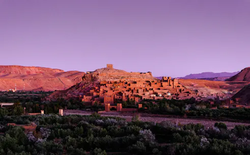 Ait Ben Haddou village at sunset with surrounding desert landscape, Ouarzazate day trip from Marrakech.