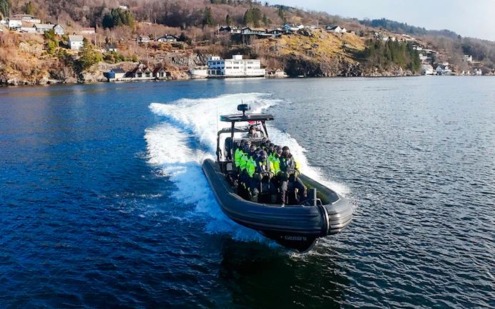 Guests on a RIB boat enjoying Alversund Fjord Safari with scenic coastal views.
