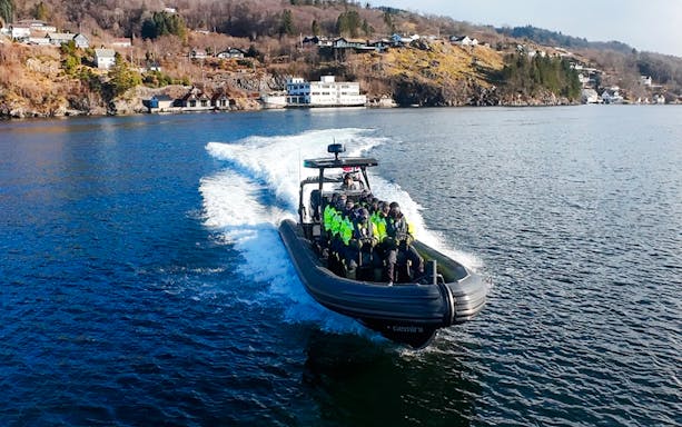 Guests on a RIB boat enjoying Alversund Fjord Safari with scenic coastal views.