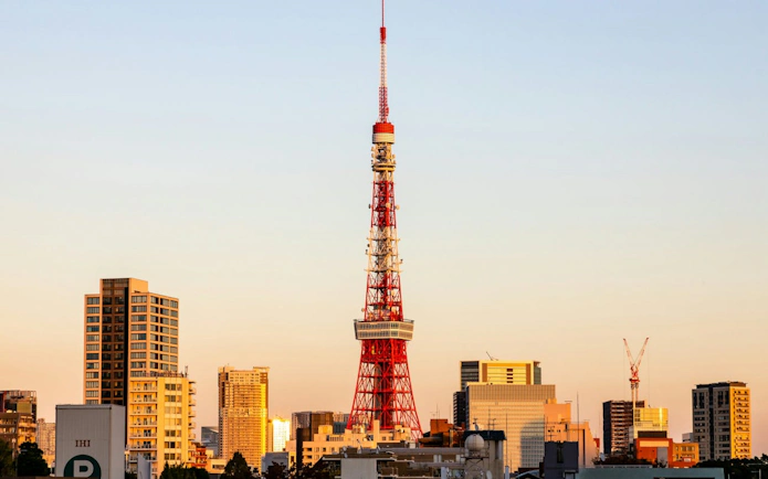 Tokyo Tower at sunset with city skyline in the background.