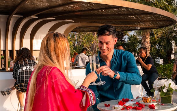 Couple toasting with champagne at Uma Lounge, Burj Al Arab.