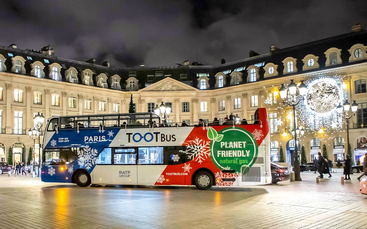 Paris Christmas Tootbus in festive lights at Place Vendôme.