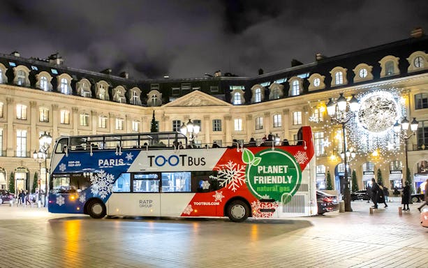 Paris Christmas Tootbus in festive lights at Place Vendôme.